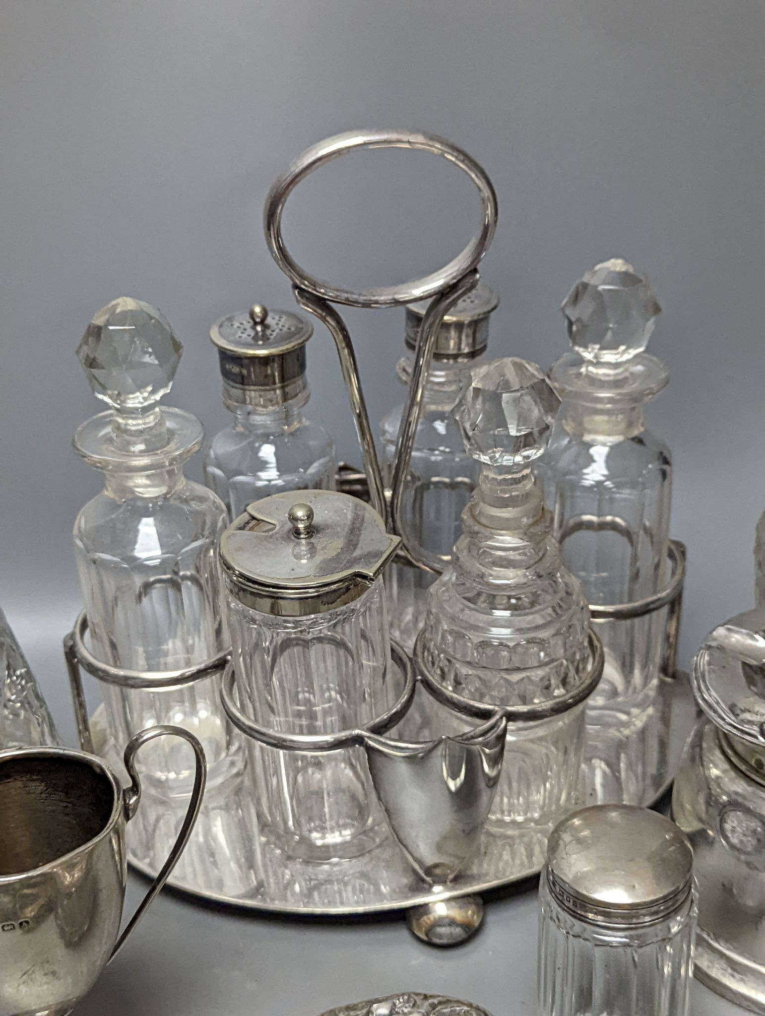 A plated cruet stand, two cased sets of silver handled tea knives, a silver domed ashtray(a.f.) silver trophy cup, four silver mounted glass jars and a plated napkin ring.